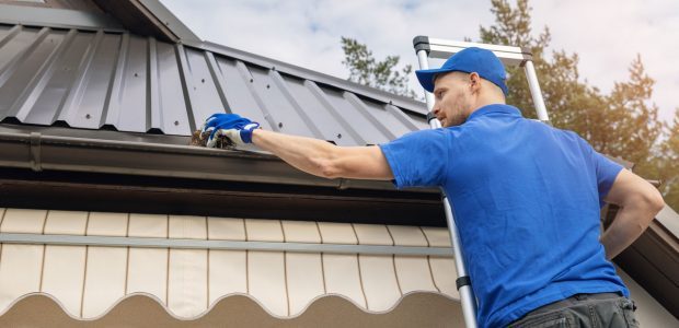 A professional strategically installing gutter system for a residential property